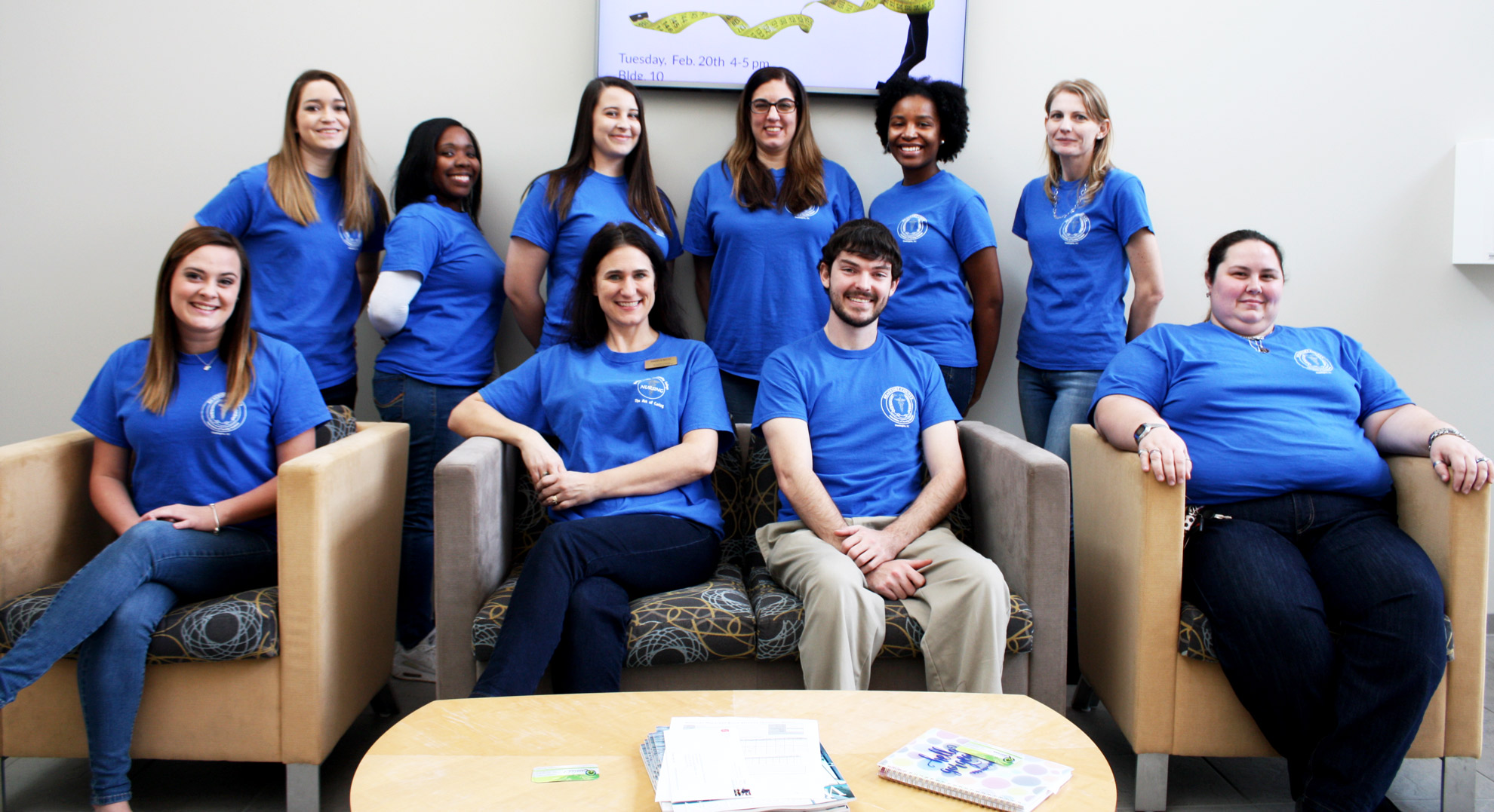 Ten students in blue t-shirts in two rows. Front row (left to right): Makayla Cutler, VP; Angela Boyd, Faculty Advisor; James Matthews, President; and Jessie Godley, Social Event Coordinator. Back row (left to right): Logan Barber, Historian; India Allen, LPN Rep; Brittany Wiggins, Historian; Kristen Battershell, Secretary; Michelle Ashe, Treasurer; and Daniell Davenport, Social Event Coordinator.  Not pictured: Morgan Peed, LPN representative.