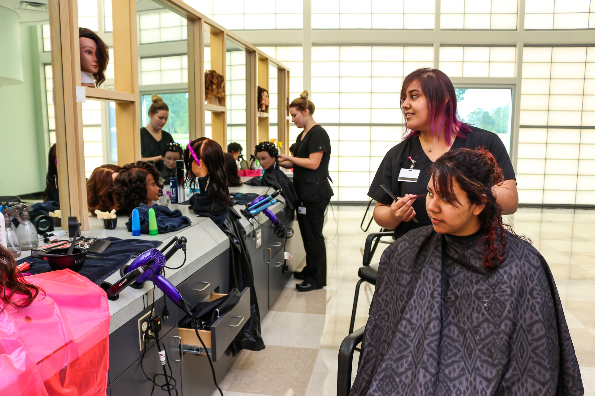 A student cutting hair in the cosmetology salon.