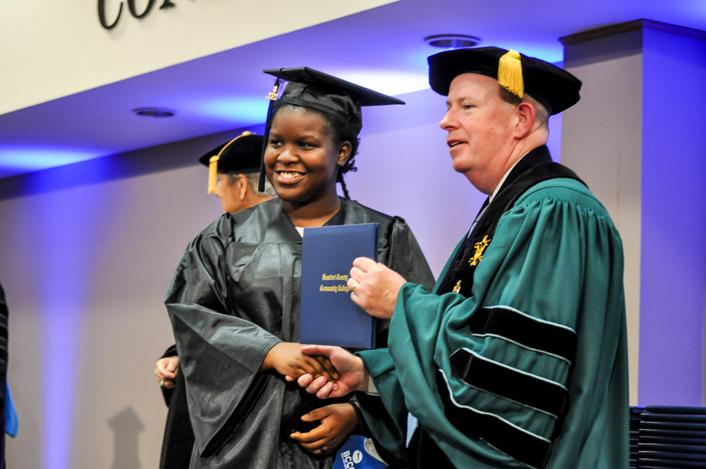 Two people shake hands at graduation